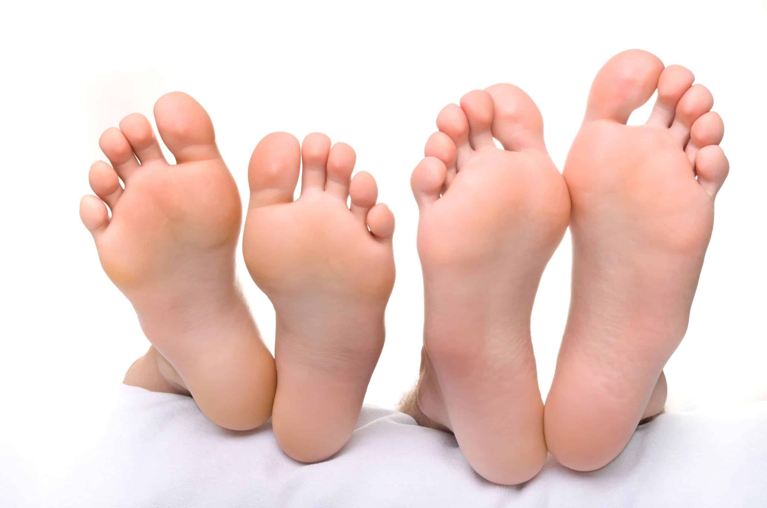 Nackte Fußsohlen einer Frau und eines Mannes nebeneinander