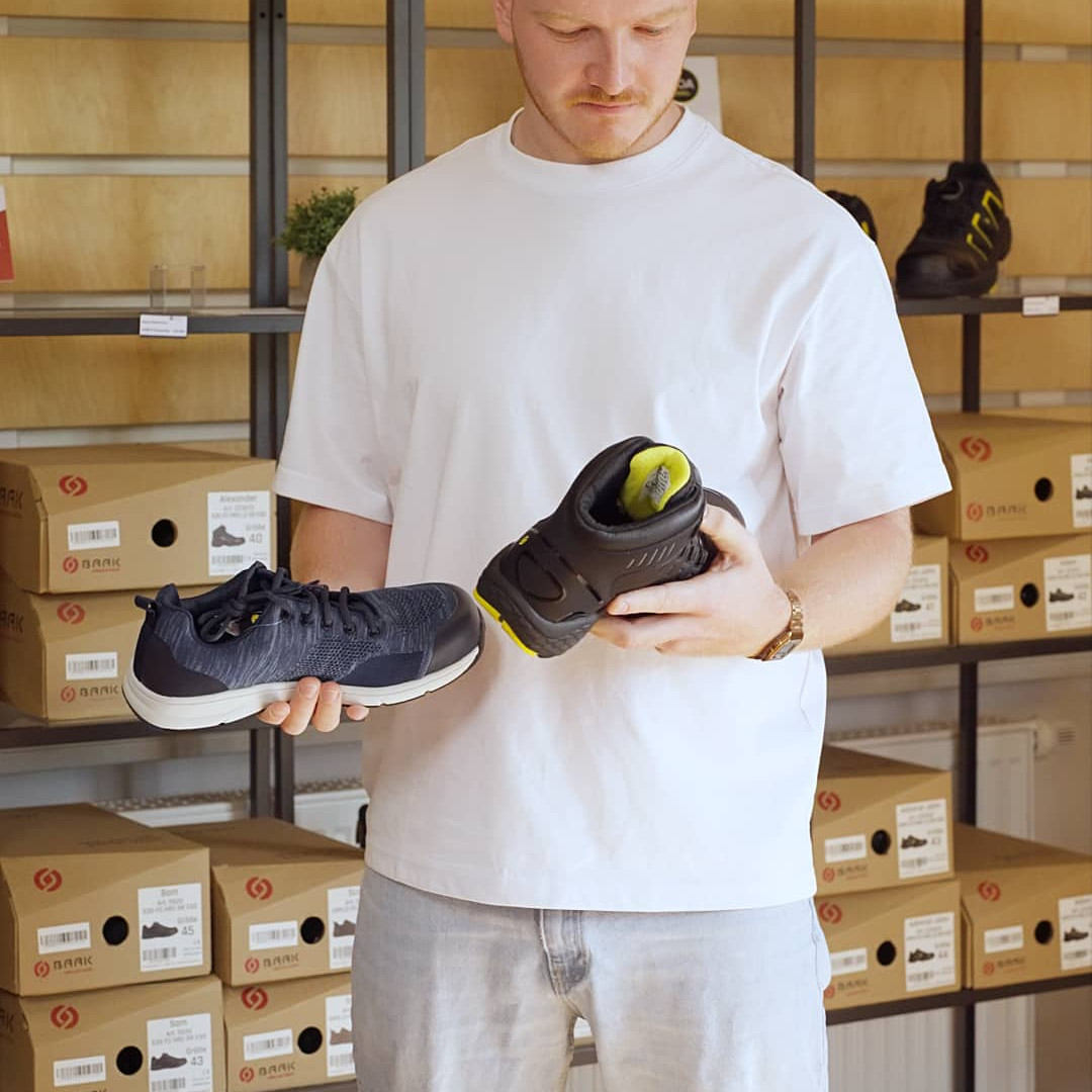 Mann h&auml;lt zwei unterschiedliche Schuhe in den H&auml;nden